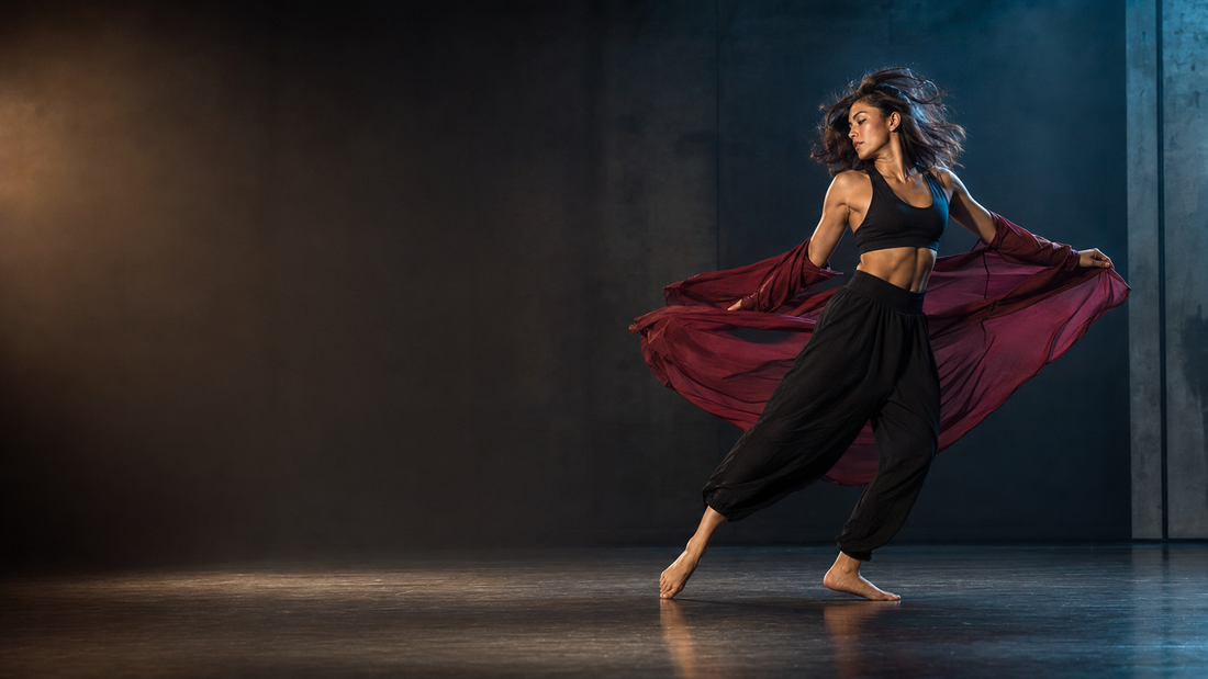 Tänzerin von Dance 4 You Konstanz in kraftvoller Drehbewegung mit wehendem, burgunderfarbenem Tuch auf dunkler Bühne